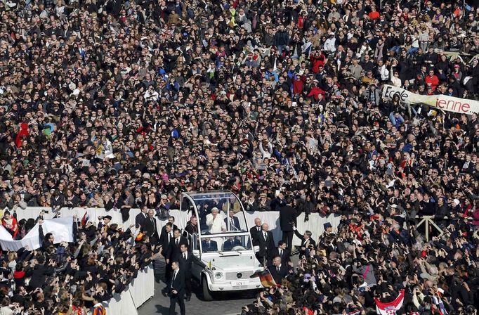 Pope Benedict XVI waves from his Popemobile as he rides through a packed Saint Peter's Square at the Vatican during his last general audience, February 27, 2013. The weekly event which would normally be held in a vast auditorium in winter, but has been moved outdoors to St. Peter's Square so more people can attend. The pope has two days left before he takes the historic step of becoming the first pontiff in some six centuries to step down instead of ruling for life. REUTERS/Stefano Rellandini (VATICAN - Tags: RELIGION) Published: Úno. 27, 2013, 10:14 dop.