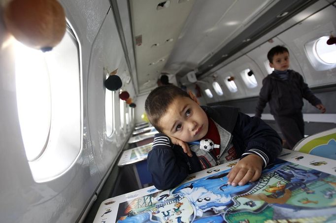 Children play in the cabin of a plane at a kindergarten in the town of Rustavi some 25 km (15 miles) south of Tbilisi, October 31, 2012. The fully functional Soviet-era Yakovlev Yak-40 plane has been installed in the kindergarten courtyard and refurbished as a children's playground. REUTERS/David Mdzinarishvili (GEORGIA - Tags: EDUCATION SOCIETY) Published: Říj. 31, 2012, 11:14 dop.