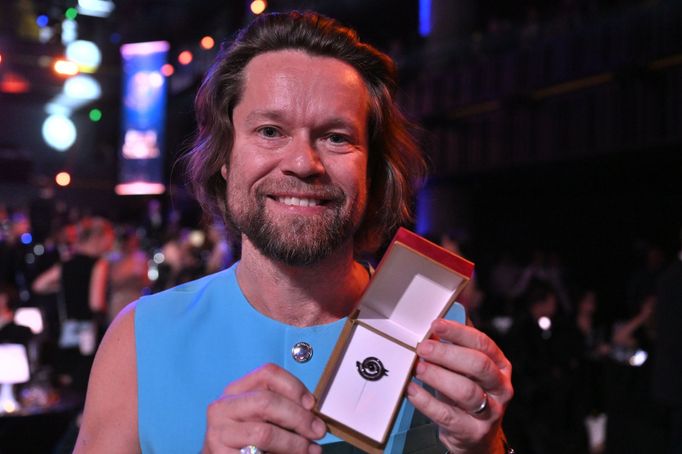 Zpěvák Richard Krajčo ukazuje bronzového slavíka, kterého v kategorii Hudební skupina získala skupina Kryštof.