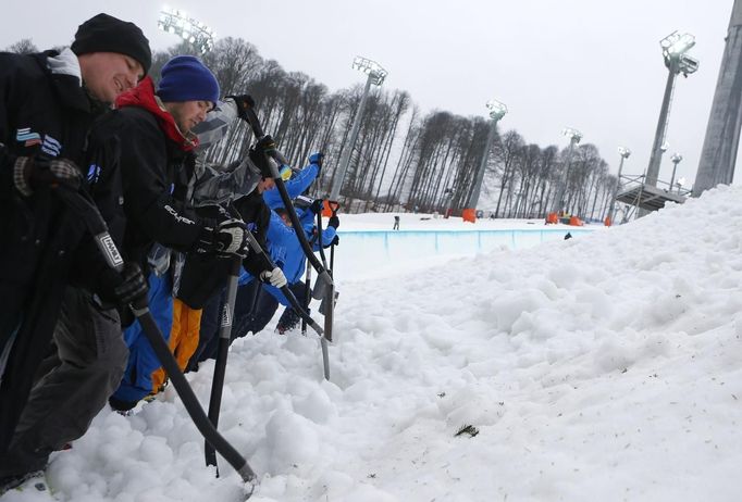 Volunteers prepare the landing place at the Extreme Park, a Sochi 2014 Winter Olympics venue for the snowboard and skiing freestyle events in Rosa Khutor near Sochi February 12, 2013. Although many complexes and venues in the Black Sea resort of Sochi mostly resemble building sites that are still under construction, there is nothing to suggest any concern over readiness. Construction will be completed by August 2013 according to organizers. The Sochi 2014 Winter Olympics opens on February 7, 2014. REUTERS/Kai Pfaffenbach (RUSSIA - Tags: CITYSCAPE BUSINESS CONSTRUCTION ENVIRONMENT SPORT OLYMPICS) Published: Úno. 12, 2013, 11:16 dop.