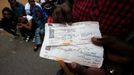 A Sudanese migrant displays his train ticket to travel to Paris on his way to Germany as he is blocked at the Franco-Italian border near Menton, France