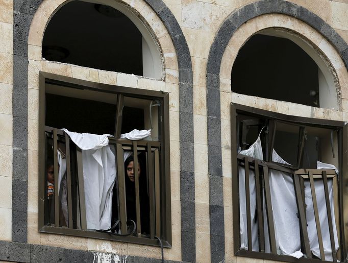 A boy and a girl look from the window of their house damaged by a car bomb attack in Yemen's capital Sanaa July 21, 2015