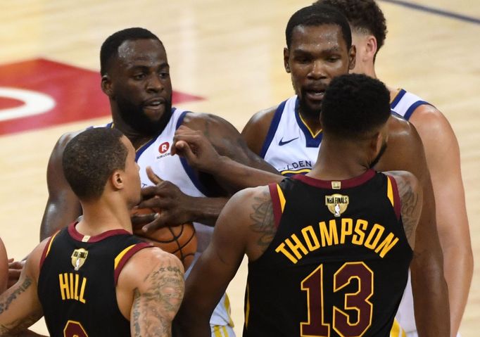 Tristan Thompson (13) z Clevelandu atakuje hráče Golden State Draymonda Greena (23).