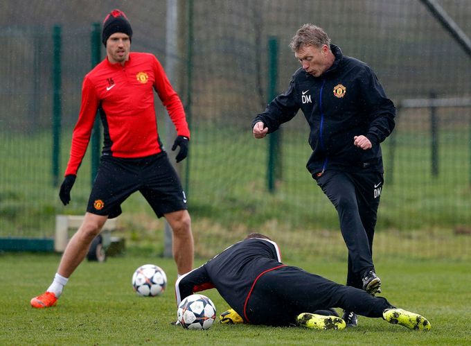 Manchester United's manager Moyes is challenged by Rooney during a training session at the club's Carrington training complex in Manchester