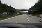 Na dálnici D5 u Prahy bagr na valníku urazil kus mostu, ten spadl na sanitku a zranil jejího řidiče