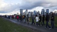 Obyvatelé Calgary sledují rozvodněnou řeku Bow v centru města.