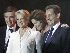Noční oslavy vítězství. Vedle Sarkozyho stojí jeho manželka Cecilila, v bílých šatech ministryně obrany Michelle Aliot-Marieová.