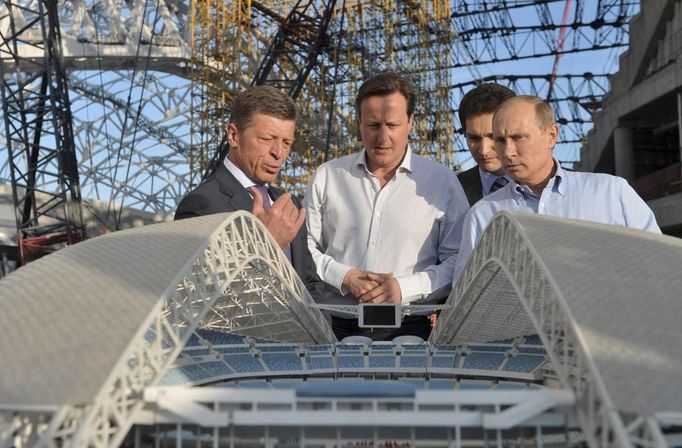 Russian President Vladimir Putin (R), British Prime Minister David Cameron (C) and Russian Deputy Prime Minister Dmitry Kozak look at a model during their visit to venues for the upcoming 2014 Winter Olympics in Sochi May 10, 2013. REUTERS/Alexei Nikolsky/RIA Novosti/Pool (RUSSIA - Tags: POLITICS SPORT OLYMPICS) ATTENTION EDITORS - THIS IMAGE HAS BEEN SUPPLIED BY A THIRD PARTY. IT IS DISTRIBUTED, EXACTLY AS RECEIVED BY REUTERS, AS A SERVICE TO CLIENTS. FOR EDITORIAL USE ONLY. NOT FOR SALE FOR MARKETING OR ADVERTISING CAMPAIGNS Published: Kvě. 10, 2013, 8:20 odp.