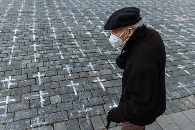 Lidé na Staroměstském náměstí v Praze spontánně uctívají oběti pandemie u křížů, které zde křídou nakreslila iniciativa Milion chvilek pro demokracii. 24 - 25. 3. 2021