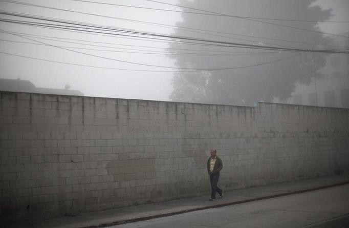 A man walks during a foggy morning in downtown Guatemala City November 11, 2012. REUTERS/Jorge Dan Lopez (GUATEMALA - Tags: SOCIETY ENVIRONMENT) Published: Lis. 11, 2012, 9:24 odp.