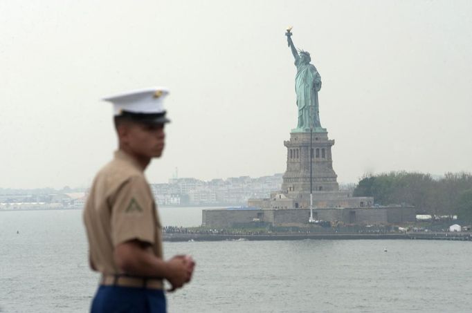 A U.S. Marine stands at the rails of the USS Wasp as the amphibious assault ship passes the Statue of Liberty during its entry into the New York Harbor for Fleet Week May 23, 2012. REUTERS/Keith Bedford (UNITED STATES - Tags: MILITARY SOCIETY CITYSPACE MARITIME) Published: Kvě. 23, 2012, 7:33 odp.