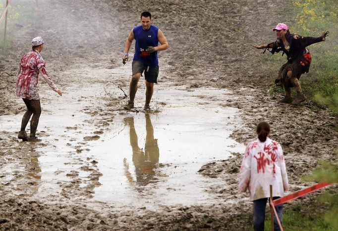 Zombies chase runners on the "Run for Your Lives" 5K obstacle course race in Amesbury, Massachusetts May 5, 2012. Runners face man-made and natural obstacles on the course, while being chased by zombies, who try to take "health" flags off the runners belts. REUTERS/Brian Snyder (UNITED STATES - Tags: SPORT SOCIETY TPX IMAGES OF THE DAY) Published: Kvě. 5, 2012, 8:16 odp.