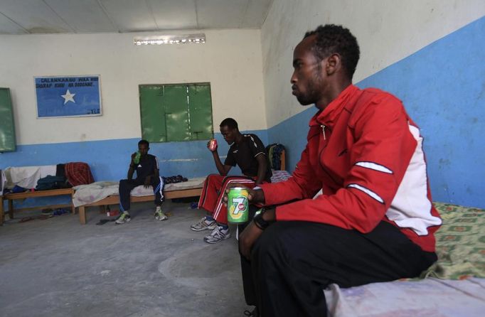 Somali athletes drink water and rest inside their room after training during preparations for the 2012 London Olympic Games in Somalia's capital Mogadishu March 14, 2012 file photo. Training in a bullet-riddled stadium where the remains of a rocket propelled grenade lies discarded on the track's edge counts as progress for Somali Olympic hopeful Mohamed Hassan Mohamed. A year ago, Mogadishu's Konis stadium was a base for Islamist militants and a work out meant at times running through the streets, dodging gun-fire and mortar shells in one of the world's most dangerous cities. To match OLY-SOMALIA-HOPES/ REUTERS/Feisal Omar/Files (SOMALIA - Tags: SPORT ATHLETICS SOCIETY OLYMPICS) Published: Čer. 11, 2012, 6:52 dop.