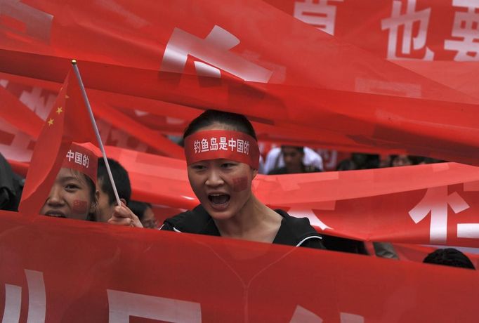 Demonstrators hold Chinese flags and banners as they yell slogans during a protest in Kunming, Yunnan province, September 15, 2012. Thousands of protesters besieged the Japanese embassy in Beijing on Saturday, hurling rocks and bottles at the building as police struggled to keep control, amid growing tensions between Asia's two biggest economies over a group of disputed islands. The Chinese characters on the headband read, "Dioayu Islands belong to China." REUTERS/Wong Campion (CHINA - Tags: MILITARY POLITICS TPX IMAGES OF THE DAY)