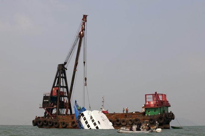 A sunken ferry is lifted out of the water after an accident off Hong Kong October 2, 2012. At least 36 people died and dozens were injured when the ferry carrying more than 120 people on a company outing collided with another ferry and sank near an island south of Hong Kong on Monday night in one of the city's worst maritime accidents. REUTERS/Tyrone Siu (CHINA - Tags: DISASTER TRANSPORT TPX IMAGES OF THE DAY) Published: Říj. 2, 2012, 2:50 dop.