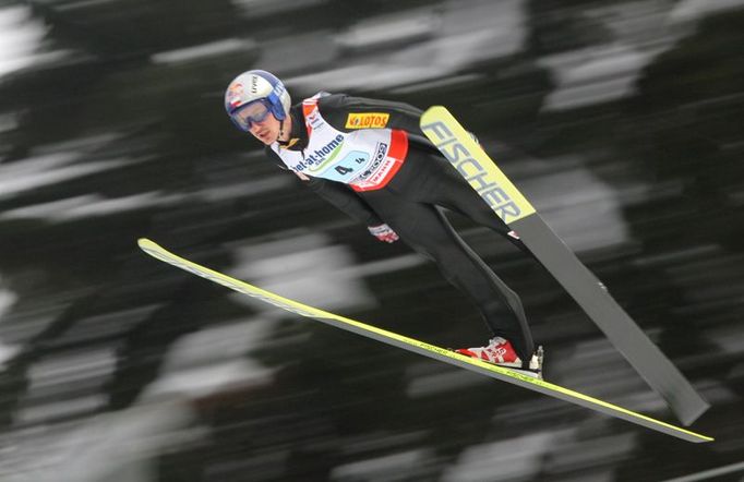 Legendární Polák Adam Malysz letí vzduchem v prvním kole soutěže družstev. Poláci skončili čtvrtí, před Českou republikou.