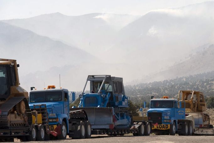 The Topaz Ranch Estates fire burns behind a line of fire equipment in Wellington, Nevada May 24, 2012. Lighter winds and higher humidity helped crews' efforts to curb the Topaz Ranch Estates wildfire that has razed more than 9 square miles (23 square km) of brush south of Carson City, charring two homes and more than a dozen outbuildings. REUTERS/James Glover II (UNITED STATES - Tags: DISASTER ENVIRONMENT) Published: Kvě. 25, 2012, 1:52 dop.