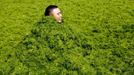 A man covers himself in algae as he plays with his friends at a seaside in Qingdao, Shandong province, July 3, 2013. REUTERS/Stringer (CHINA - Tags: SOCIETY ENVIRONMENT) CHINA OUT. NO COMMERCIAL OR EDITORIAL SALES IN CHINA Published: Čec. 3, 2013, 12:04 odp.