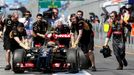 Lotus Formula One driver Pastor Maldonado of Venezuela is being pushed down the pits by mechanics during the first practice session of the Australian F1 Grand Prix at the