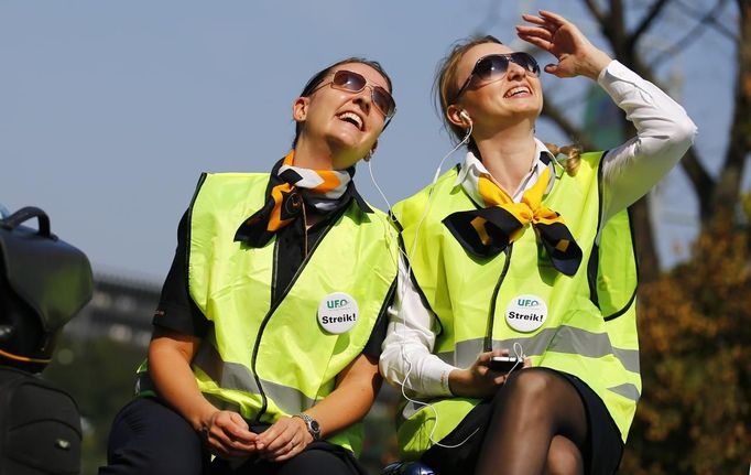 Two members of German air carrier Lufthansa cabin crew union "UFO" enjoy the sun as they take part in a strike outside a Lufthansa office building at the Fraport airport in Frankfurt, September 4, 2012. Lufthansa passengers face widespread flight disruption after cabin crew representatives said they continue a series of strikes over pay and cost-cutting measures at Germany's largest airline. The UFO union, which represents around two-thirds of Lufthansa's 19,000 cabin crew, late on Thursday called on its members to strike on Tuesday in Frankfurt and Berlin. REUTERS/Kai Pfaffenbach (GERMANY - Tags: BUSINESS EMPLOYMENT CIVIL UNREST TRANSPORT) Published: Zář. 4, 2012, 12:44 odp.