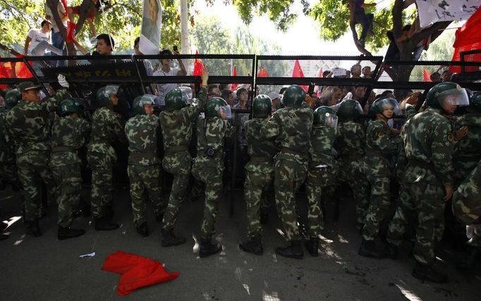 Riot police block demonstrators during a protest outside the Japanese embassy in Beijing September 15, 2012. Hundreds of people protested in front of the Japanese embassy in Beijing on Saturday, throwing objects at the building as police struggled to keep control, amid growing tensions between Asia's two biggest economies over a group of disputed islands. REUTERS/David Gray (CHINA - Tags: CIVIL UNREST POLITICS)