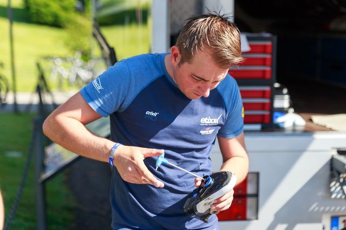 Nicolas Coosemans šroubuje zarážky (takzvané kufry) na tretru jednoho z jezdců týmu Etixx - Quick-Step.