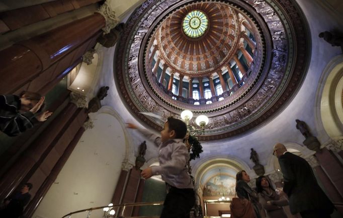 Jaidon Santos-Volpe (2nd L) plays with his friend Sam Crawford-Cloonan (L) as his two mothers Theresa Volpe (C) and Mercedes Santos (2nd R) speak to their lawyer Erik Roldan as they wait for the start of a Senate Executive Committee hearing on same-sex marriages at the Illinois State Legislature in Springfield, Illinois, January 2, 2013. Santos and Volpe are a same-sex couple raising two of their biological children as they struggle to get same-sex marriages passed into law in Illinois. Picture taken January 2, 2013. REUTERS/Jim Young (UNITED STATES - Tags: SOCIETY) Published: Bře. 25, 2013, 6:07 odp.