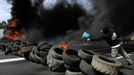 A coal miner pours gasoline to burn tires to block the N-630 road during a demonstration in La Robla, near Leon, northern Spain June 20, 2012. The miners were protesting against the government's proposal to decrease funding for coal production. REUTERS/Eloy Alonso (SPAIN - Tags: CIVIL UNREST POLITICS BUSINESS EMPLOYMENT) Published: Čer. 20, 2012, 12:57 odp.