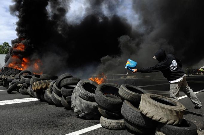 A coal miner pours gasoline to burn tires to block the N-630 road during a demonstration in La Robla, near Leon, northern Spain June 20, 2012. The miners were protesting against the government's proposal to decrease funding for coal production. REUTERS/Eloy Alonso (SPAIN - Tags: CIVIL UNREST POLITICS BUSINESS EMPLOYMENT) Published: Čer. 20, 2012, 12:57 odp.