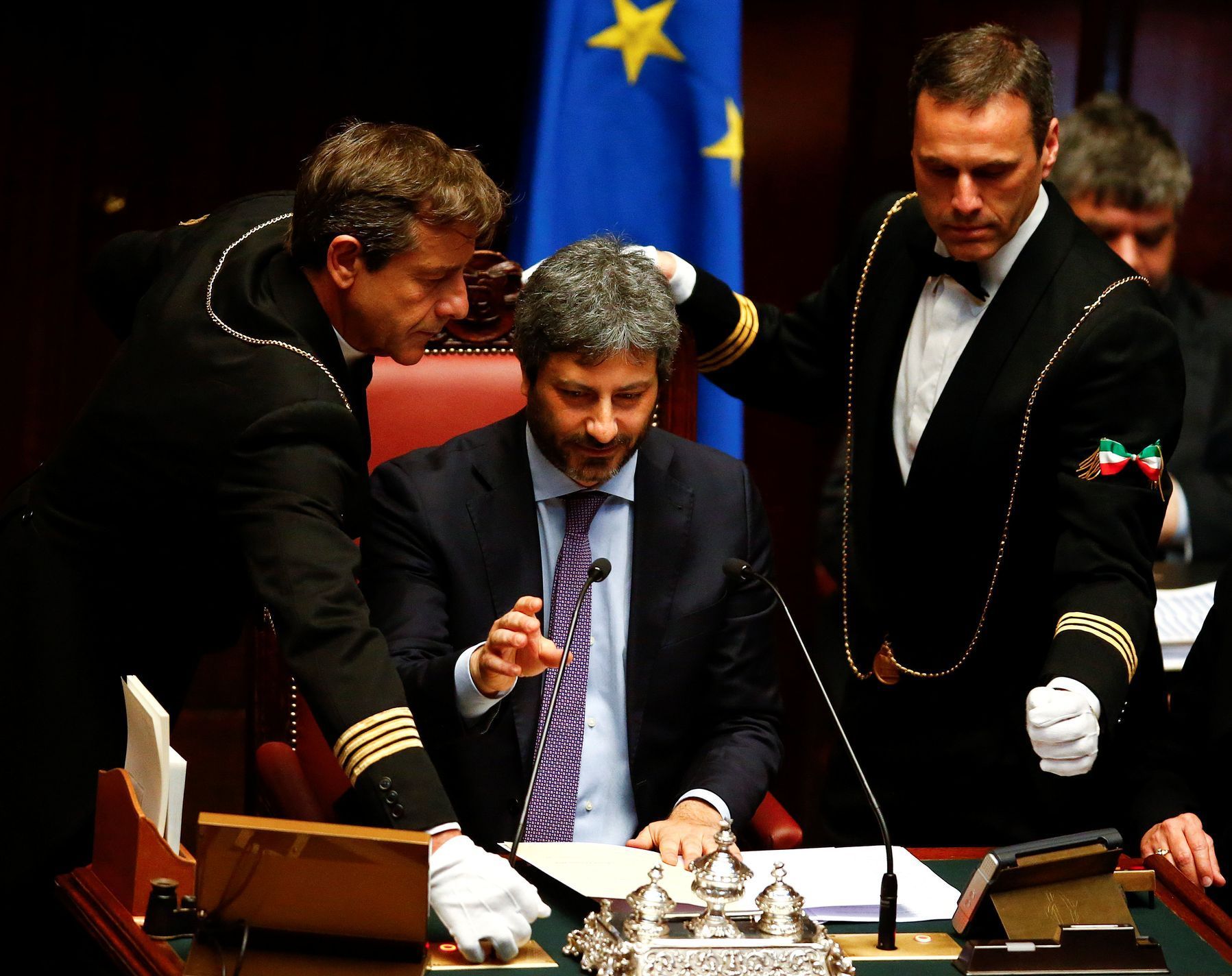 Asistenti kontrolují mikrofon nově zvoleného předsedy italské Poslanecké sněmovny Roberta Fica