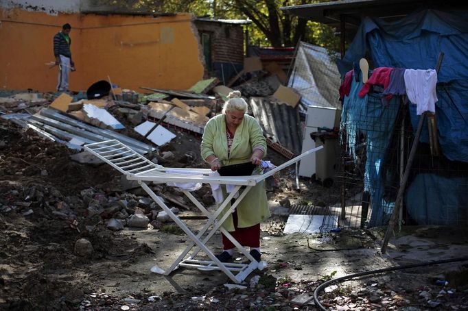 Covadonga Jimenez hangs out clothes as Angel Duval (L) cleans debris from what used to be his bedroom after an excavator demolished it at the Spanish gypsy settlement of Puerta de Hierro outside Madrid November 8, 2011. Fifty-four families have been living in Puerta de Hierro, on the banks of the Manzanares river for over 50 years. Since the summer of 2010, the community has been subject to evictions on the grounds that the dwellings are illegal. Families whose houses have been demolished, move in with relatives whose houses still remain while the debris keeps piling up around them as more demolitions take place. Picture taken November 8, 2011. REUTERS/Susana Vera (SPAIN - Tags: SOCIETY) ATTENTION EDITORS - PICTURE 17 OF 31 FOR PACKAGE 'GYPSY SITE DEMOLISHED' SEARCH 'GYPSY SITE' FOR ALL IMAGES Published: Lis. 5, 2012, 4:12 odp.