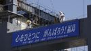 Workers wearing protective suits and masks are seen on top of a foundation construction for the storage of melted fuel rods, next to the No.4 reactor at Tokyo Electric Power Company's (TEPCO) tsunami-crippled Fukushima Daiichi nuclear power plant in Fukushima prefecture March 6, 2013, ahead of the second-year of anniversary of the the March 11, 2011 tsunami and earthquake. The banner reads: "Unite the Heart, Gambaro! Fukushima (Go! Fukushima)". REUTERS/Issei Kato (JAPAN - Tags: DISASTER ANNIVERSARY) Published: Bře. 6, 2013, 10:31 dop.