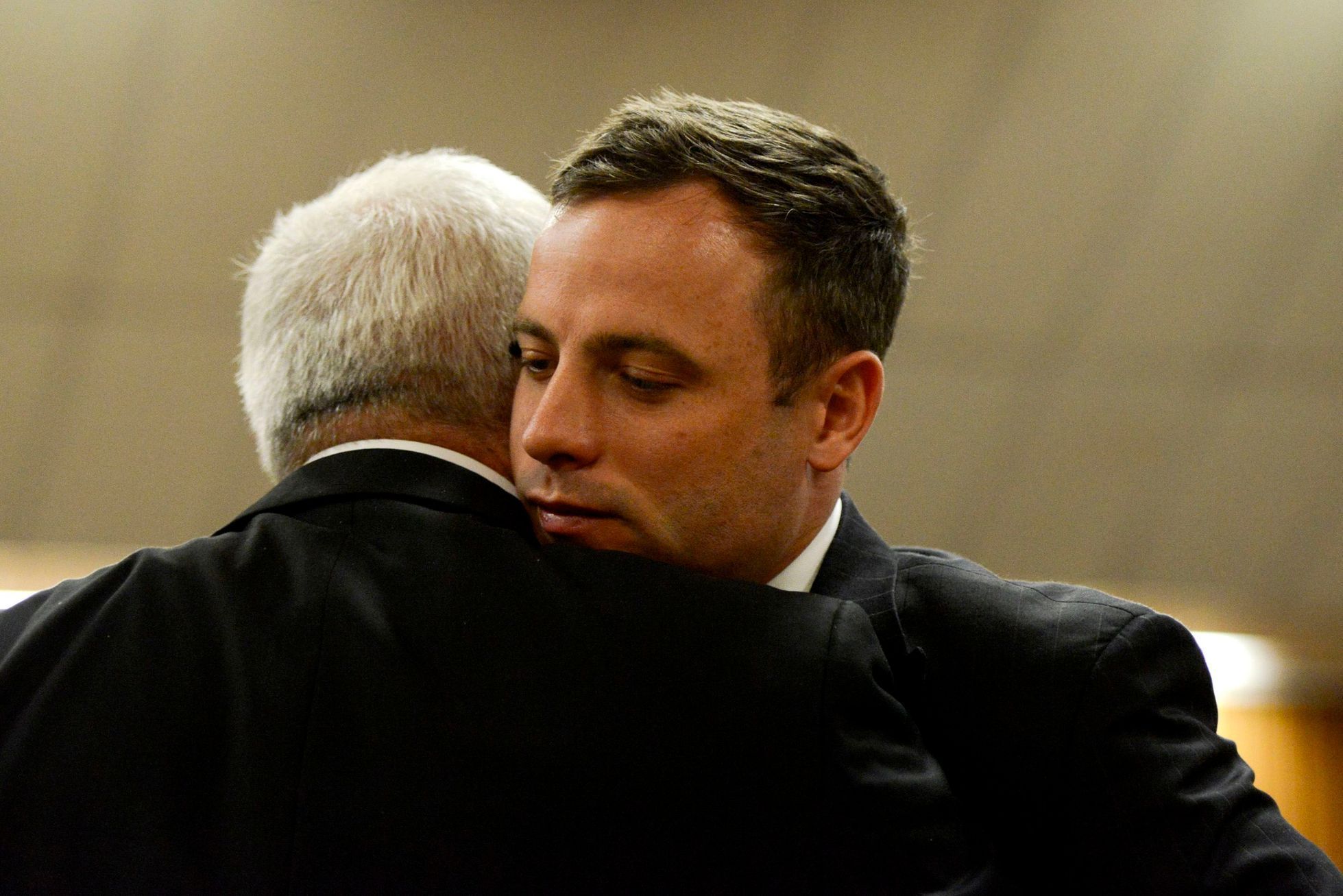 Pistorius se před vynesením rozsudku objímá se svým otcem