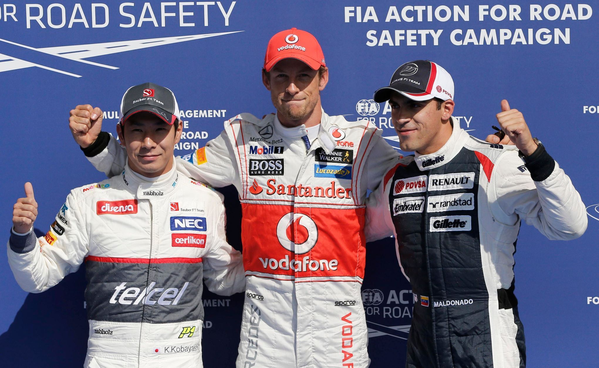 Jezdec F1 Jeson Button z McLarenu (uprostřed), Kamui Kobajaši ze Sauberu a Pastor Maldonado z Williamsu slaví první tři místa v kvalifikaci Velké ceny Belgie 2012.