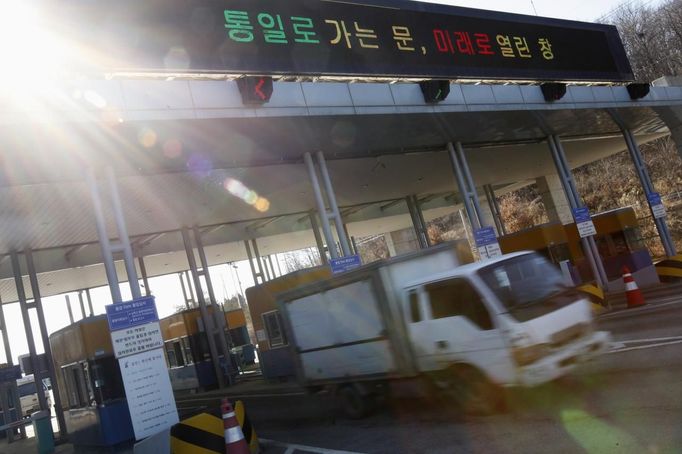 A South Korean truck heads towards the South's CIQ (Customs, Immigration and Quarantine) office from the Kaesong Industrial Complex (KIC), just south of the demilitarised zone which separates the two Koreas, in Paju, north of Seoul March 11, 2013. North Korea has torn up the armistice that ended its 1950s conflict and shut down a humanitarian hotline with the South, but one project keeps operating at full swing -- an industrial park run with the South on its own side of the world's most heavily militarised border. The board reads, "Door to unification, window to the future". REUTERS/Kim Hong-Ji (SOUTH KOREA - Tags: MILITARY POLITICS) Published: Bře. 11, 2013, 10:41 dop.