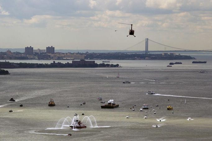 Fire boats spray water in front of the Space Shuttle Enterprise as it floats up the Hudson River June 6, 2012, as it rides past the New York skyline on a barge to be placed at the Intrepid Sea, Air and Space Museum. REUTERS/Lucas Jackson (UNITED STATES - Tags: SCIENCE TECHNOLOGY TRANSPORT) Published: Čer. 6, 2012, 5:11 odp.