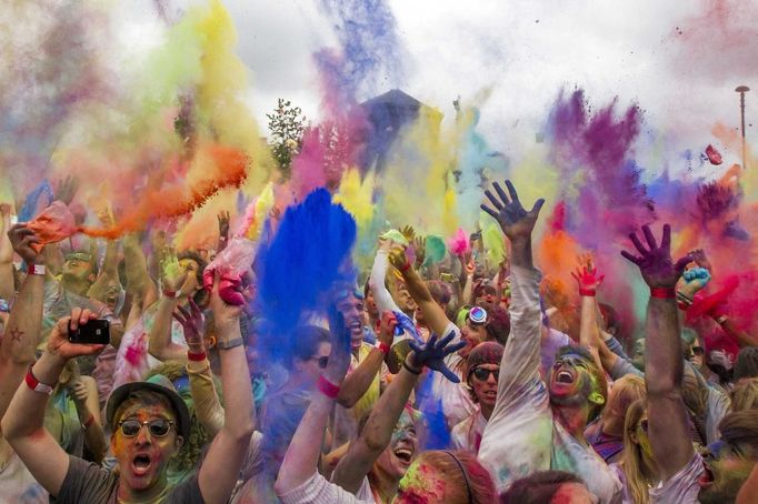 People throw coloured powder in the air during Holi festival celebrations in Berlin, July 29, 2012. Holi, also known as the festival of colours, is a festival celebrated in India and other Hindu countries that in its original form heralds the beginning of spring. The Berlin event brought Indian Djs, acrobatics and dance to the German capital. REUTERS/Thomas Peter (GERMANY - Tags: SOCIETY) Published: Čec. 29, 2012, 3:18 odp.