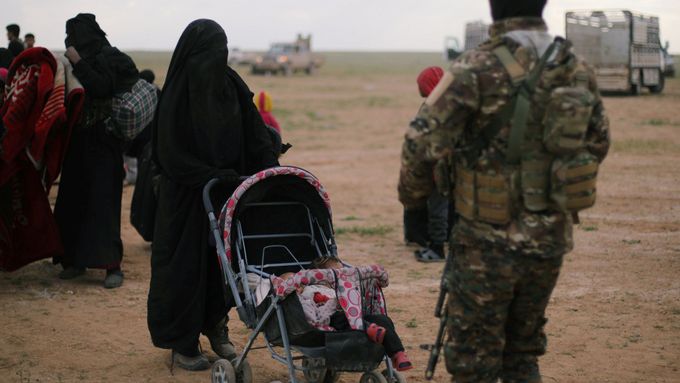 Voják Syrských demokratických sil (SDF) kontroluje ženy, které odešly z vesnice Baghúz. Poslední, kterou stále drží Islámský stát.