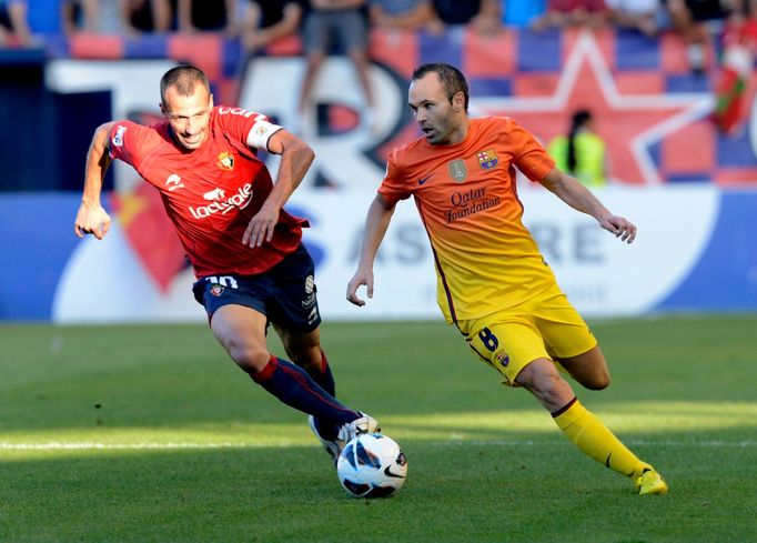 Fotbalista Barcelony Andrés Iniesta běží s míčem před Franciscem Punaiem v utkání La Ligy 2012/13 s Osasunou.