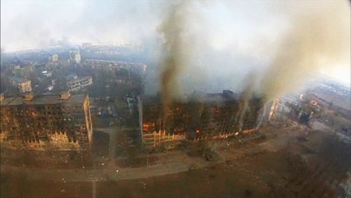 Letecký pohled ukazuje kouř stoupající z poškozených obytných budov po výbuchu během ruské invaze na Ukrajinu v ukrajinském Mariupolu 14. března 2022.