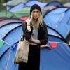 A festival goer stands in the rain as she arrives at Worthy farm in Somerset on the second day of the Glastonbury Festival