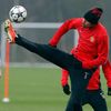 Manchester United's Ferdinand jumps for a ball as Mata looks on during a training session at the club's Carrington training complex in Manchester