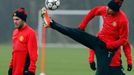 Manchester United's Ferdinand jumps for a ball as Mata looks on during a training session at the club's Carrington training complex in Manchester