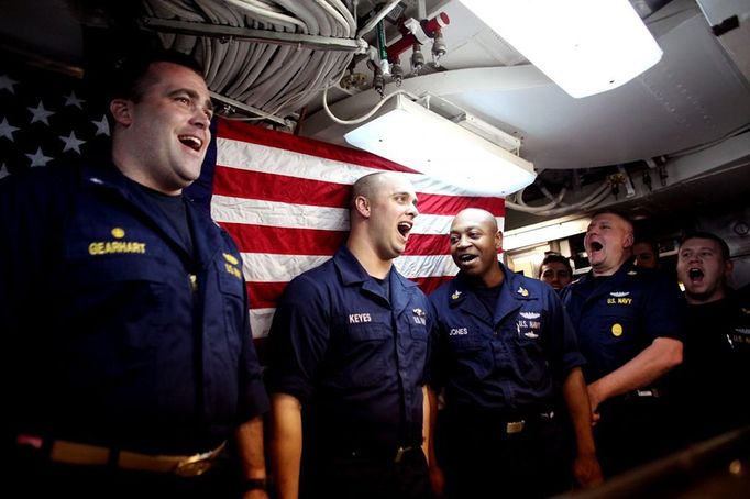 April 24, 2011 - Cape Canaveral, Florida, U.S. - -- Cape Canaveral, Fla. -- Culinary Specialist Seaman Tyler Keyes, middle, of Stillwater, Minnesota, shown with Commander John Gearhart, left, and Culinary Specialist First Class Shawn Jones, right, cheer after receiving his Submarine qualification pins during a Dolphin presentation in the Crew's Mess aboard the USS Annapolis (SSN 760), a S6G nuclear reactor powered fast attack submarine, sailing from Cape Canaveral on Sunday. The pins were first authorized for use in 1941. To ''Qualify Submarines,'' a submariner must possess an in-depth knowledge of ship's construction, operation, and damage control and demonstrate his reliability under battle conditions. The USS Annapolis measures 362 ft. in length and 33 ft. at the beam, a diving depth of over 400 ft., 27+ mph, 12 vertical launch missile tubes, 4 torpedo tubes, ( automatický překlad do češtiny )