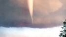 White tornado forms from swirling supercell thunderstorm near Mulvane, Kansas on June 12, 2004. Sto White F3 tornado forms from swirling supercell thunderstorm near Mulvane, Kansas on June 12, 2004. Storm chasers watch as the funnel reaches toward the ground, the tornado eventually wreaking a path of destruction.