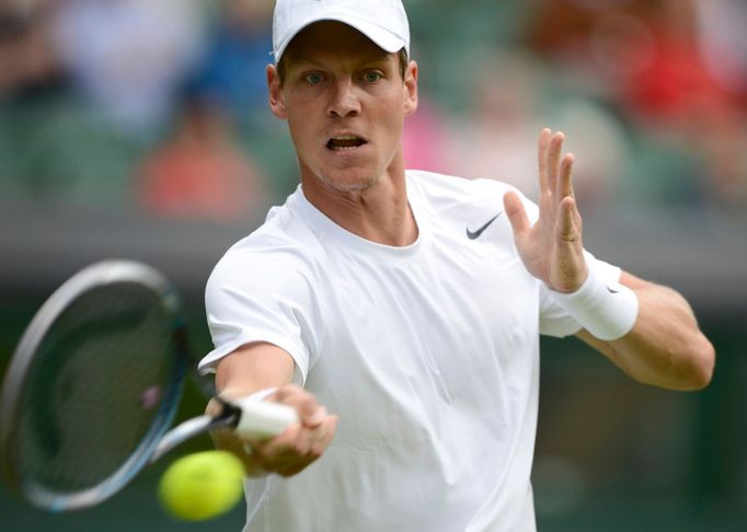 Český tenista Tomáš Berdych odráží míček během utkání s Lotyšem Ernestem Gulbisem v 1. kole Wimbledonu 2012.