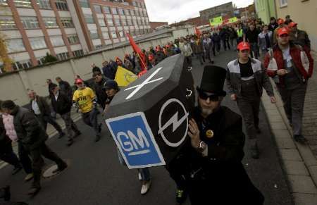 Zaměstnanci Opelu nesou rakev s logy General Motors a Opel během stávky v Ruesselsheimu