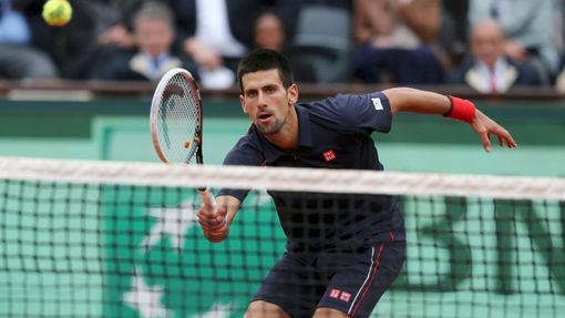 Novak Djokovič posílá krátký míček na Rafaela Nadala během finále French Open 2012.
