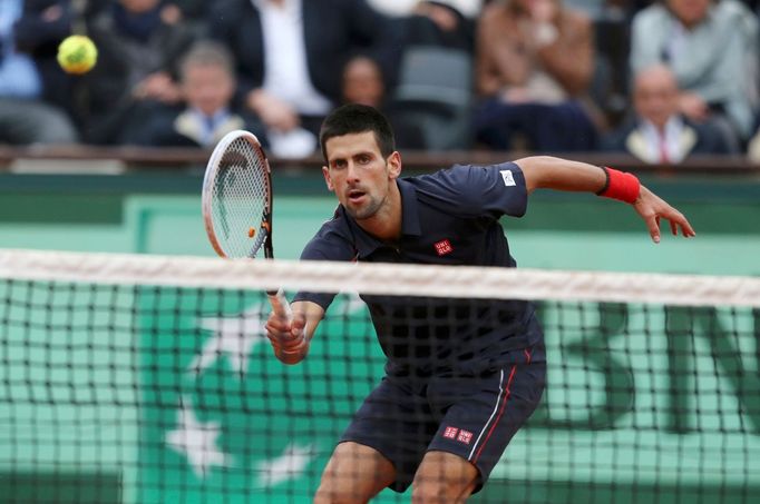 Novak Djokovič posílá krátký míček na Rafaela Nadala během finále French Open 2012.