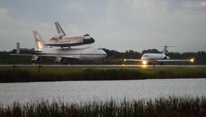 The space shuttle Endeavour leaves Kennedy Space Center for the last time in Florida, morning of September 19, 2012. Endeavour, attached to a NASA modified 747 aircraft, lifts off and will end up at the California Science Center museum where it will be put on display. Endeavour was to leave the space center on September 17 but was delayed because of bad weather between Florida and Texas, where it will make its first stop before heading to California. REUTERS/Michael Brown (UNITED STATES - Tags: SCIENCE TECHNOLOGY TRANSPORT) Published: Zář. 19, 2012, 1:23 odp.